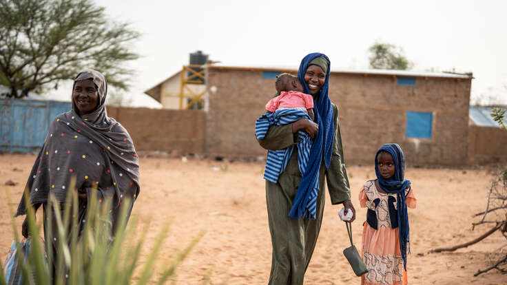 Kvinnor och barn som flytt kriget i Sudan går på en väg efter att ha besökt RESCUE:s hälsocenter i Tchad.